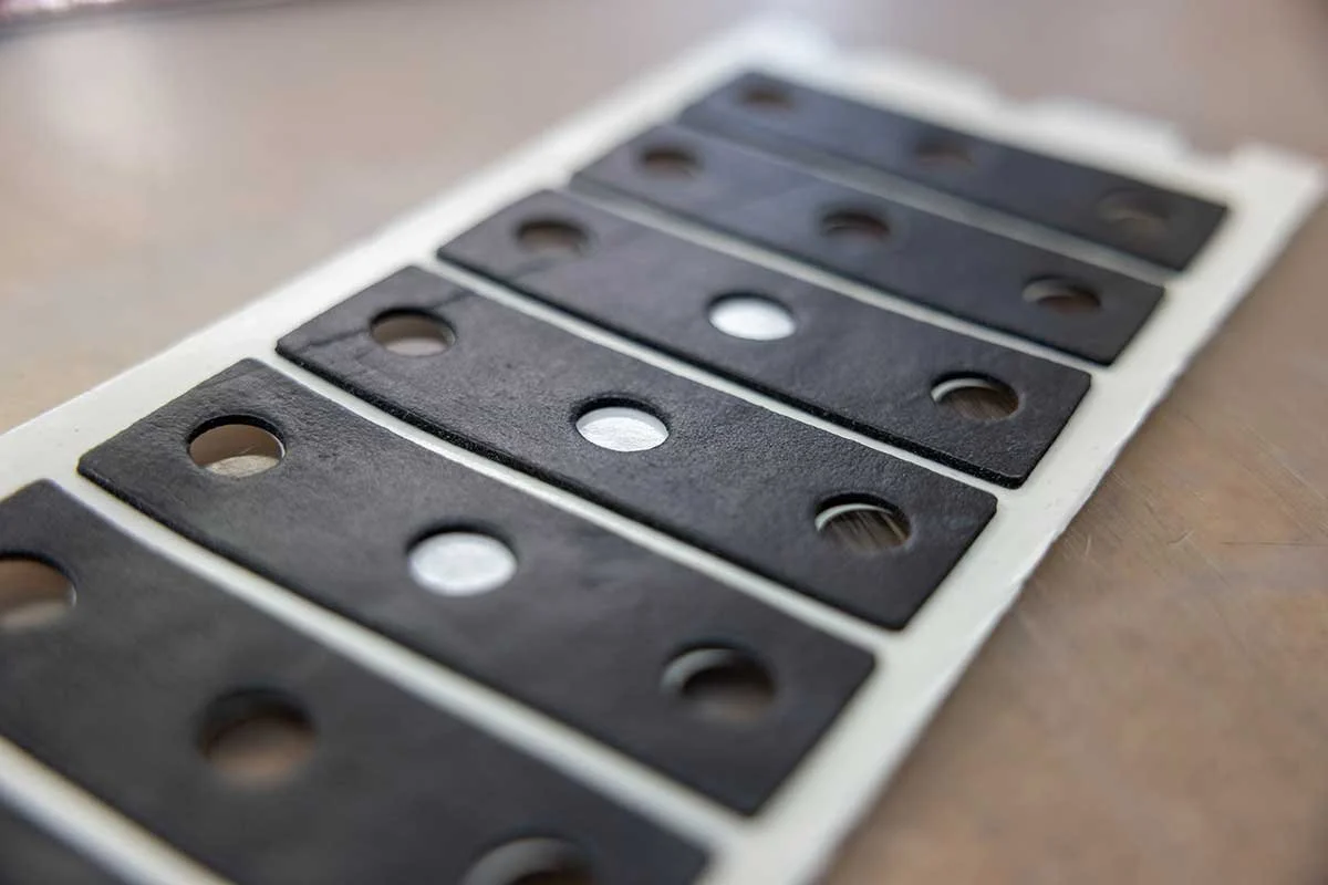 Set of black razor blades on white paper sheet.